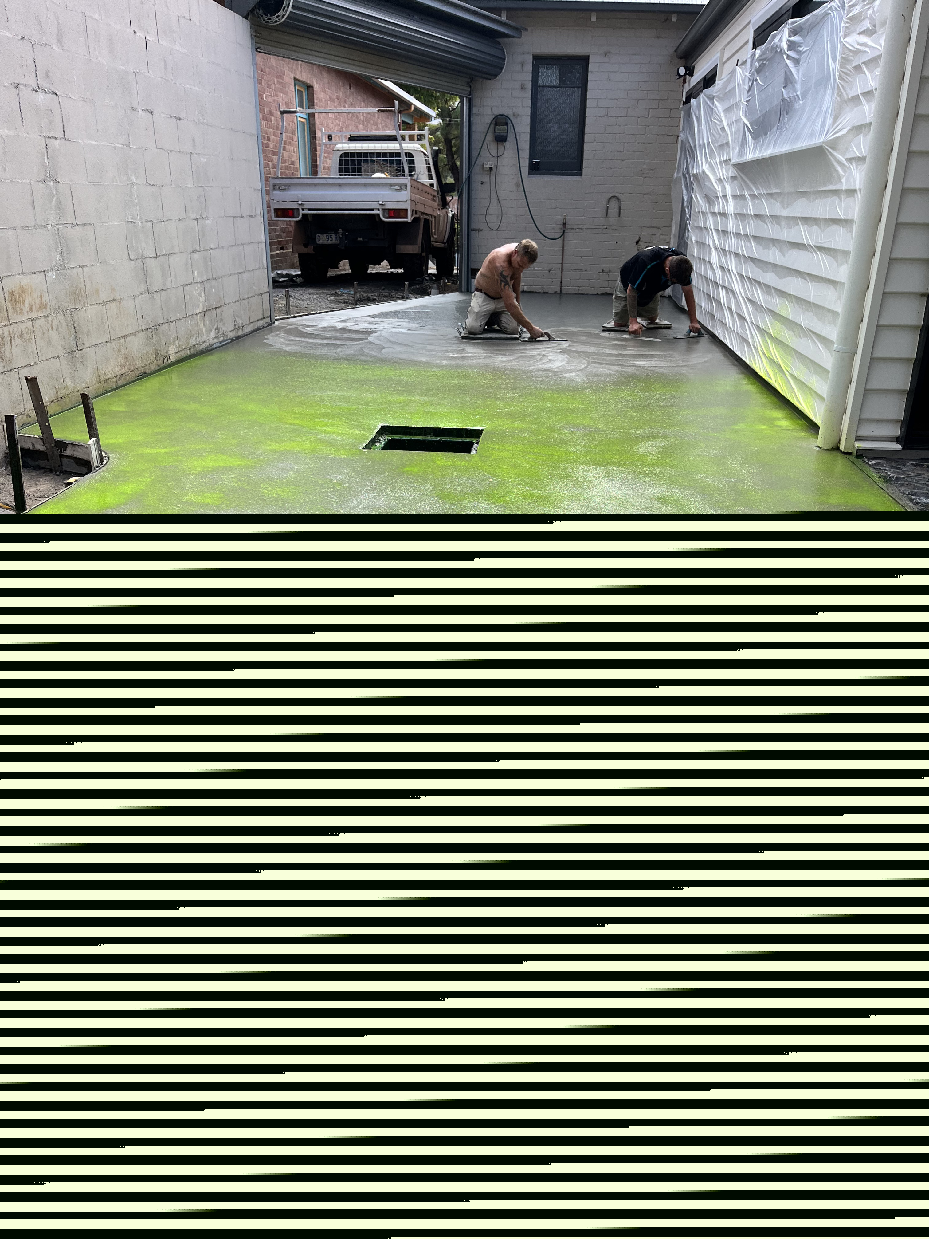 Two concreters hand-finishing a concrete floor in a narrow garage passageway, Southern Tasmania